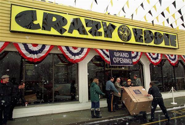 Image: Workers bring out a large-screen television at the grand opening of a new Crazy Eddie electronics store