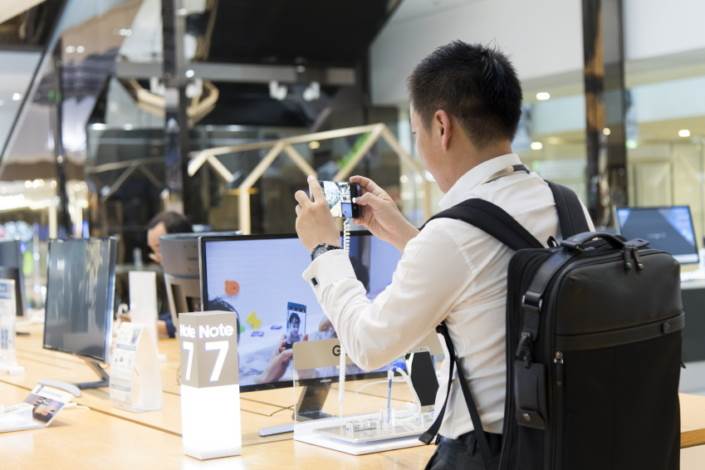 A customer tries to see how fast the Galaxy Note7's camera can capture the moment for himself.