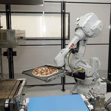 Image: A robot places a pizza into an oven at Zume Pizza