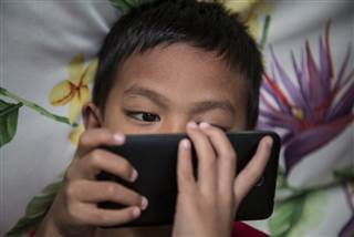 Image: A child looks at a mobile phone
