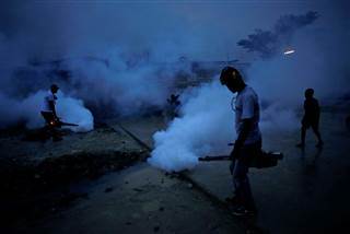 Image: Workers of the Ministry of Public Health and Population fumigate in the street against mosquito breeding to prevent diseases such as malaria, dengue and Zika, during a fumigation campaign in Port-au-Prince, Haiti