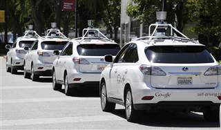 Image:  A row of Google self-driving cars are shown outside the Computer History Museum in Mountain View, Calif.