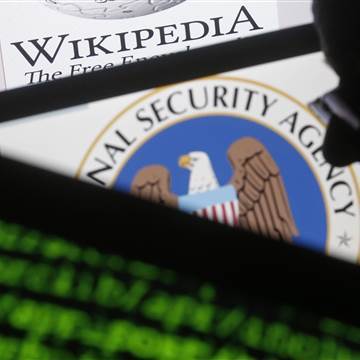 Image: A man is seen near cyber code and the U.S. National Security Agency logo in this photo illustration taken in Sarajevo