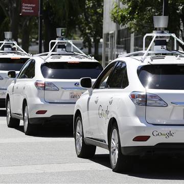 Image:  A row of Google self-driving cars are shown outside the Computer History Museum in Mountain View, Calif.