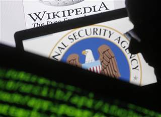 Image: A man is seen near cyber code and the U.S. National Security Agency logo in this photo illustration taken in Sarajevo