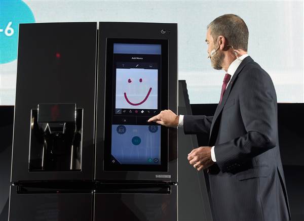 Image: An LG employee  demonstrates the LG Smart InstaView Door-in-Door refrigerato