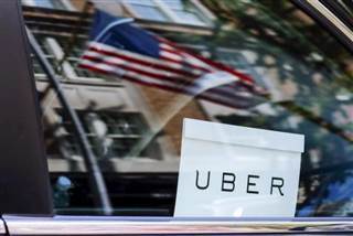 An Uber sign is seen in a car in New York