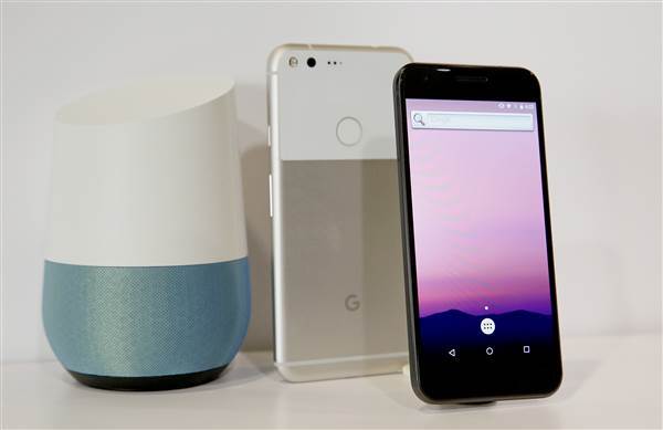 Image: The new Google Pixel phone is displayed next to a Google Home smart speaker