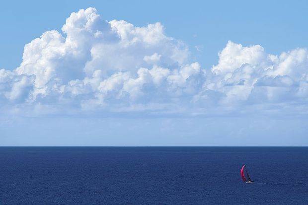 yacht_with_red_spinnaker_at_full_sail_on_blue_ocean_with_clouds-100682846-primary.idge_.jpg