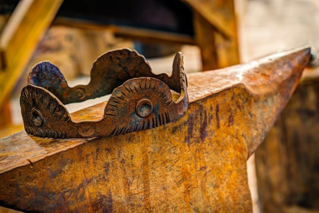 Rusted crown sitting on an anvil.