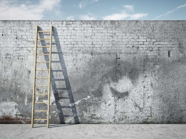 shutterstock 120020251 ladder on wall in front of blue sky white clouds