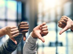 Are we worse at cloud computing than 10 years in the past? four hands raised with thumbs down in front of window with blurred light