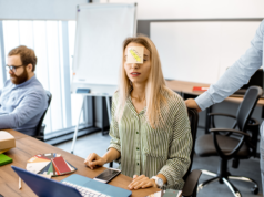 Defeating Task Paralysis: 88% of Gen Z Trust AI to Handle Ov… Tired woman with sticker on the head in the office.