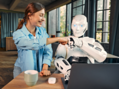 Can AI Be Trusted? 7% Rise In AI Optimism Challenges Traditi… Woman and robot using a laptop bumping fists.