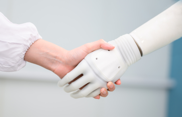 Woman shaking hands with a robot.