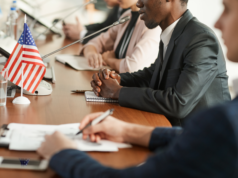 AI Deployment within the Public Sector: DHS Unveils Comprehensiv… Government hearing session with the US flag on the table.