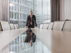 78% of Executives Plan to Invest More in AI An executive standing on a conference table.