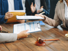 Lawsuit Alleges Microsoft Trained AI on Private LinkedIn Mes… Business people and lawyers discussing contract papers sitting at the table.