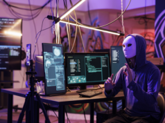 New GhostGPT Chatbot Creates Malware and Phishing Emails Hacker in anonymous mask recording video.