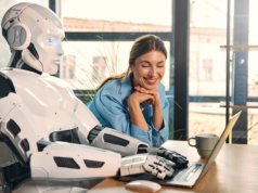 What is Your AI Tool’s Personality Type? Find Out Robot and woman working on laptop in office.