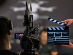 Marvel Directors on AI in Films: ‘Artists Need to Lead the I… Back view of a cameraman and a hand holding a board clapper.