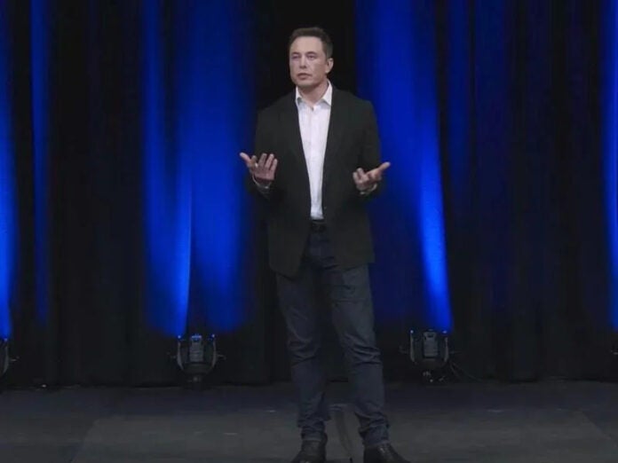 Elon Musk presenting on stage.