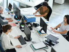 The Rise of Ghostworking: 58% of Workers Faking Productivity… Four employees working hard inside the office.