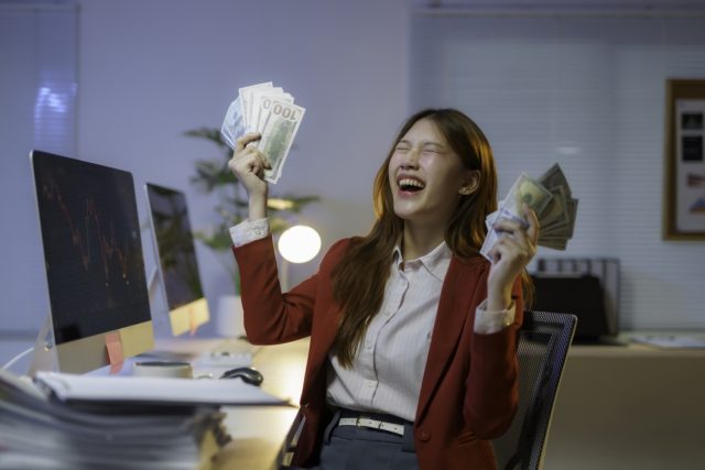 1749316786_Want-a-Raise-Use-and-Maintain-Your-AI-Skills.jpeg Stock photo of a businesswoman celebrating with cash in her hands.