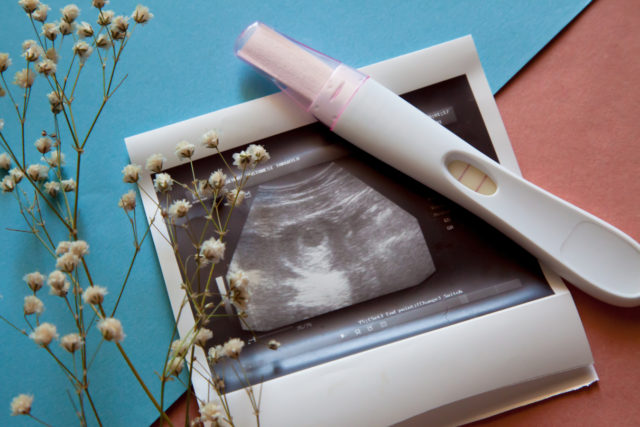 1751952527_First-AI-Assisted-Pregnancy-Offers-Hope-for-Severe-Male-Infe.jpg Ultrasound scan of an unborn baby of fifth week with a pregnancy test on the blue-pink background.