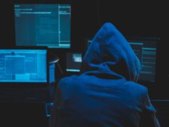NPM assaults and the safety of software program provide chains Hacker using computer for organizing massive data breach attack on goverment servers. Hacker in dark room surrounded computers