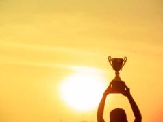 How GitHub gained software program growth Winner holding golden trophy cup above head sun and golden sky in background