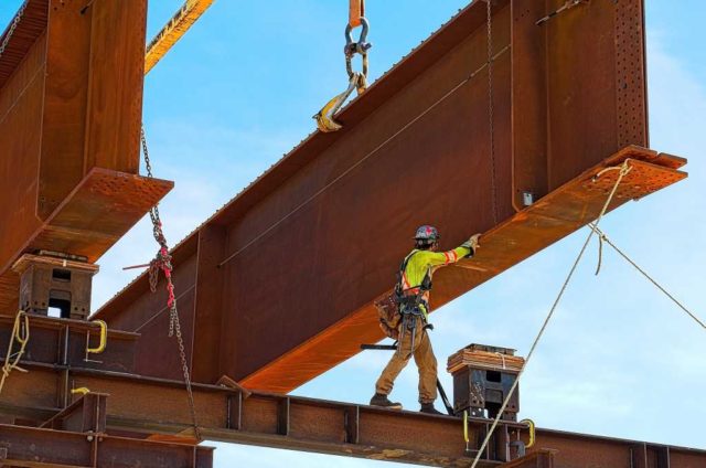 Python-has-a-friend-in-Rust.jpg Rusty steel girder and two meter web installed on a bridge abutment and scaffolding as part of a new freeway interchange. Building construction infrastructure project.