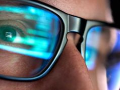 Using Valkey on Azure and in .NET Aspire Focused developer coder wears glasses working on computer looking at programming code data cyber security digital tech reflecting in spectacles developing software program, focus on eye close up view.