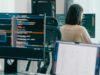 CrowdStrike identifies 5 new AI immediate injection… Group Adult Asia male, female freelance typing write prompt AI bot IT app smart program nomad, video game, terminal with coding language, user interface, designer, big data center on desktop computer.