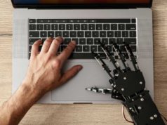 SpaceXAI launches Grok 4.5, touts decrease coding-task… image of a human and robot hand typing at a laptop