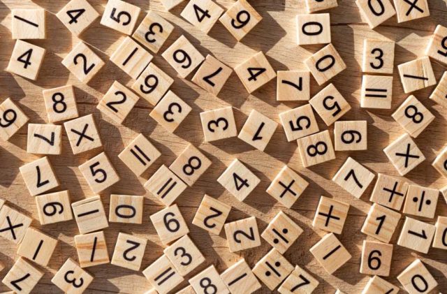 shutterstock 1912506373 scattered wooden tiles with numbers and signs